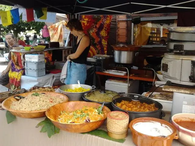 Grands plats de salades, semoule et curry sur un stand