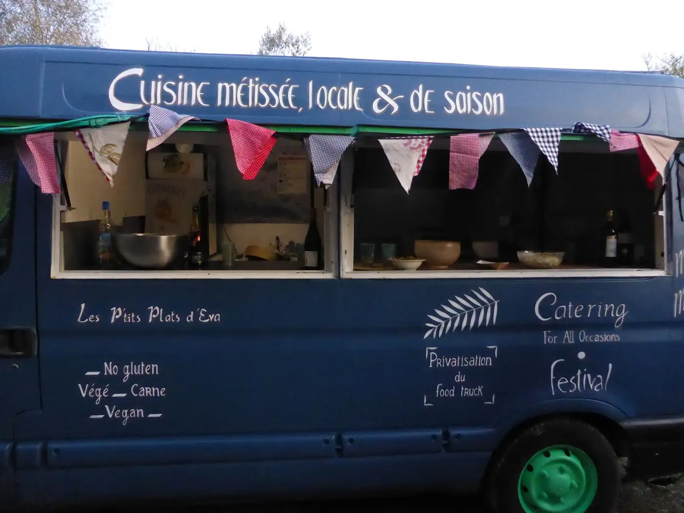 Le food truck bleu des P'tits Plats d'Éva, décoré de fanions